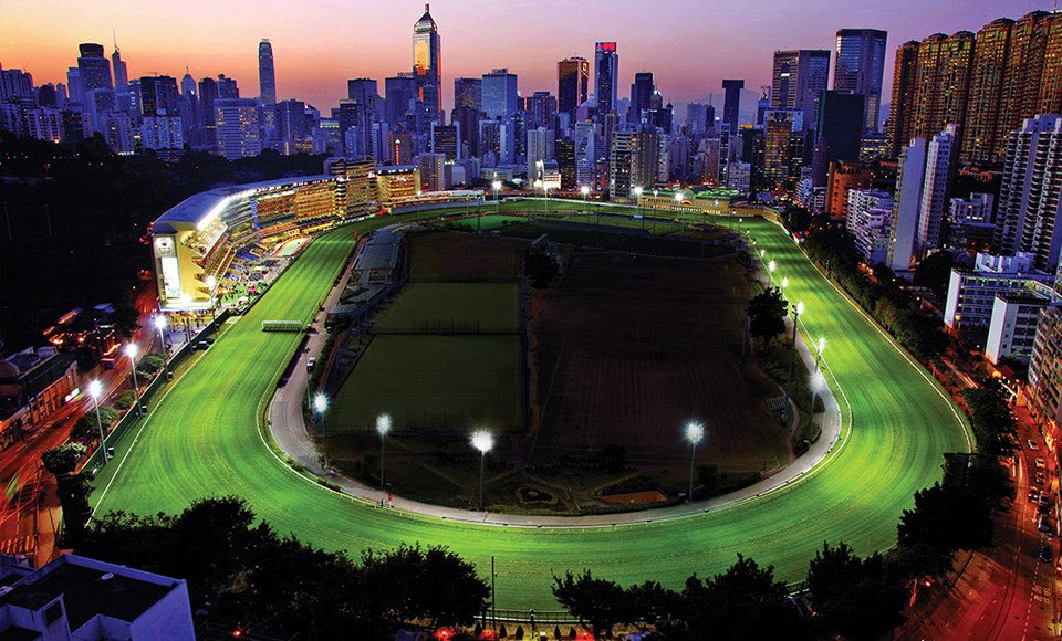 Happy Valley Racecourse under lights during evening races on May 7, 2025 – Hong Kong Jockey Club event.