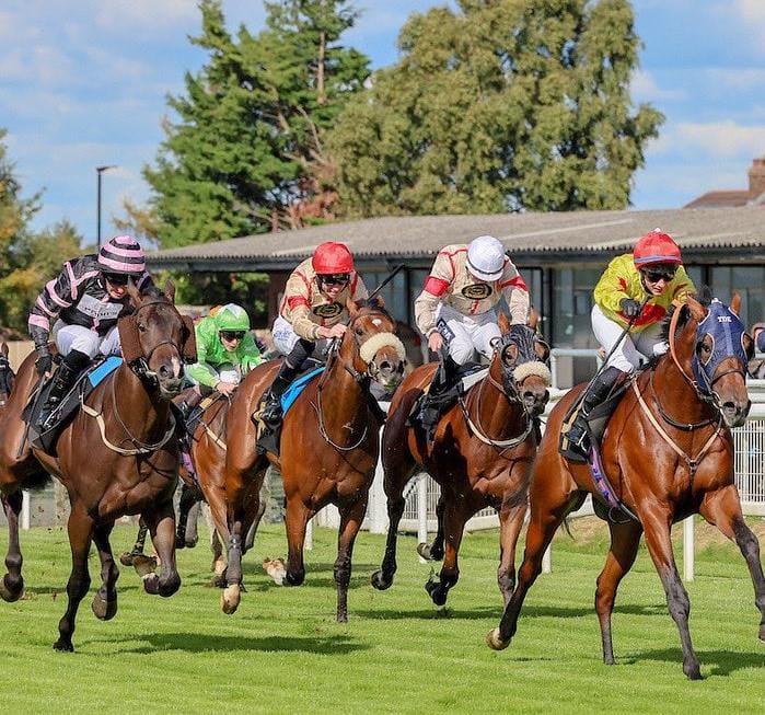 Horses galloping past the stands at Carlisle Racecourse during the opening day of the 2025 flat season