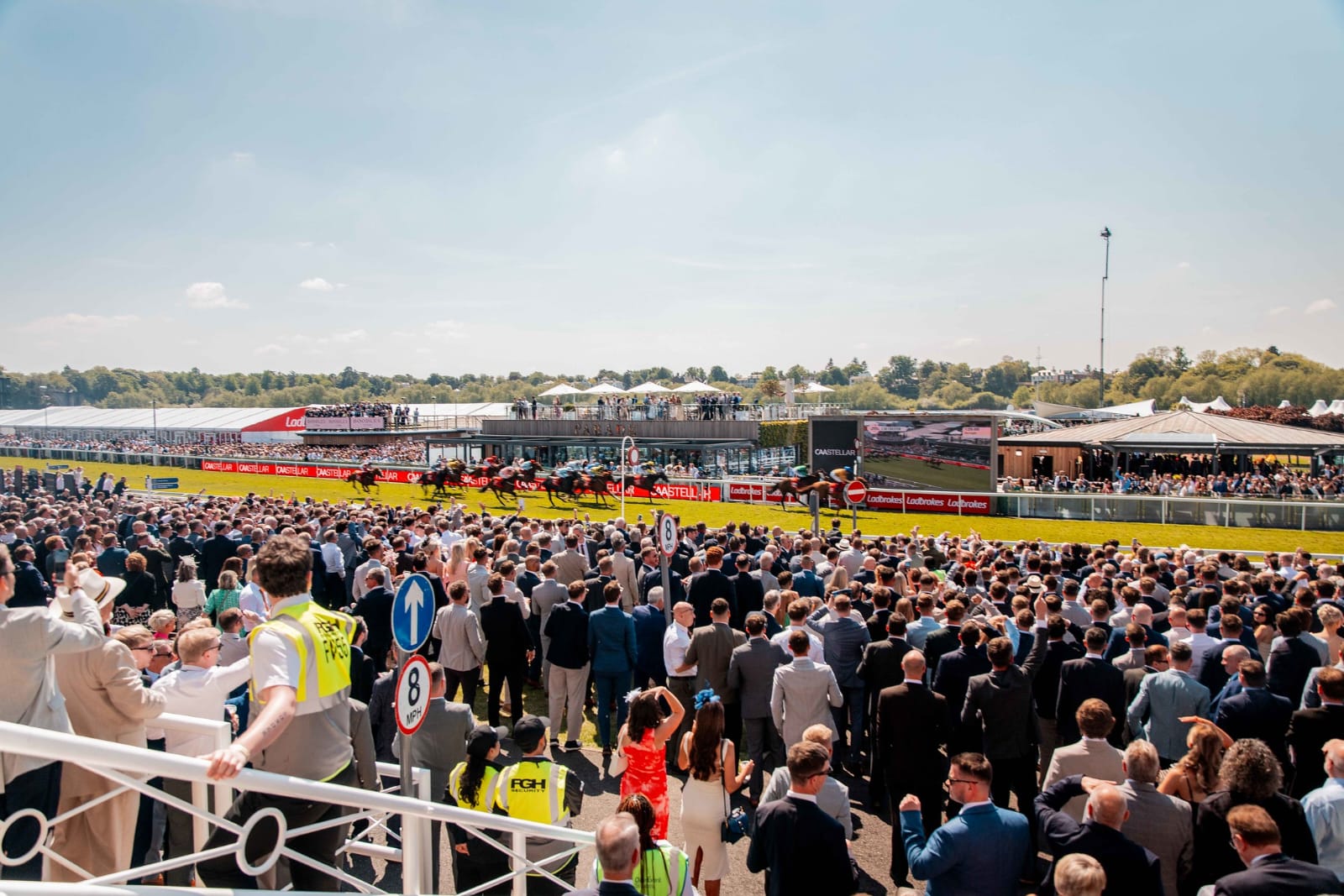 Families enjoying Roman Day at Chester Racecourse with horse racing, inflatables, and live performances in the background