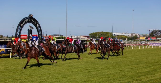 Racegoers dressed in black, white, and red at Eagle Farm Racecourse on Star Stradbroke Day 2025, enjoying thrilling races and fashion festivities.