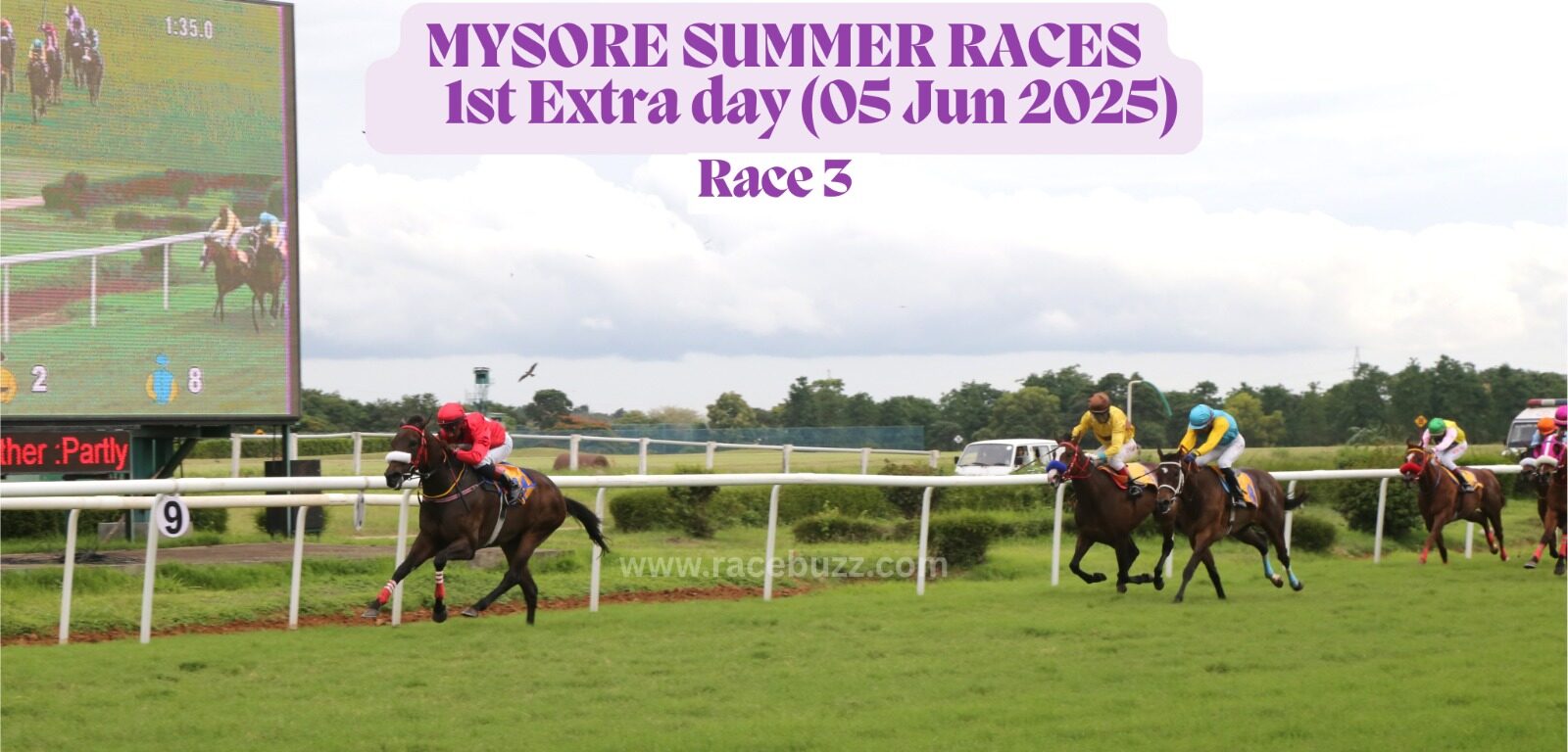 Racehorses sprint toward the finish during Race 5 of the Mysore Summer Races extra day on June 5, 2025, with the leading horse in red clearly ahead; a large screen shows the race in progress beside the track.