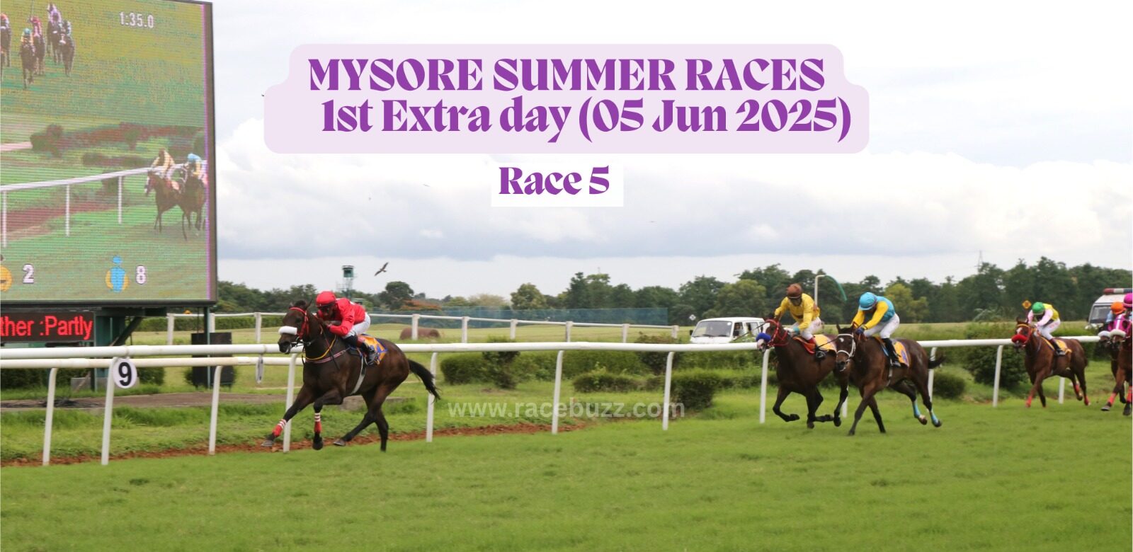 Racehorses sprint toward the finish during Race 5 of the Mysore Summer Races extra day on June 5, 2025, with the leading horse in red clearly ahead; a large screen shows the race in progress beside the track.