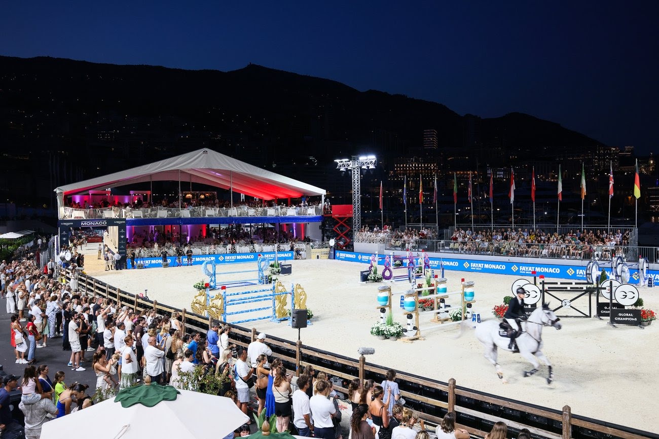 Simon Delestre riding Cayman Jolly Jumper mid-air over a fence under Monaco’s floodlit arena during the Longines Global Champions Tour Grand Prix.