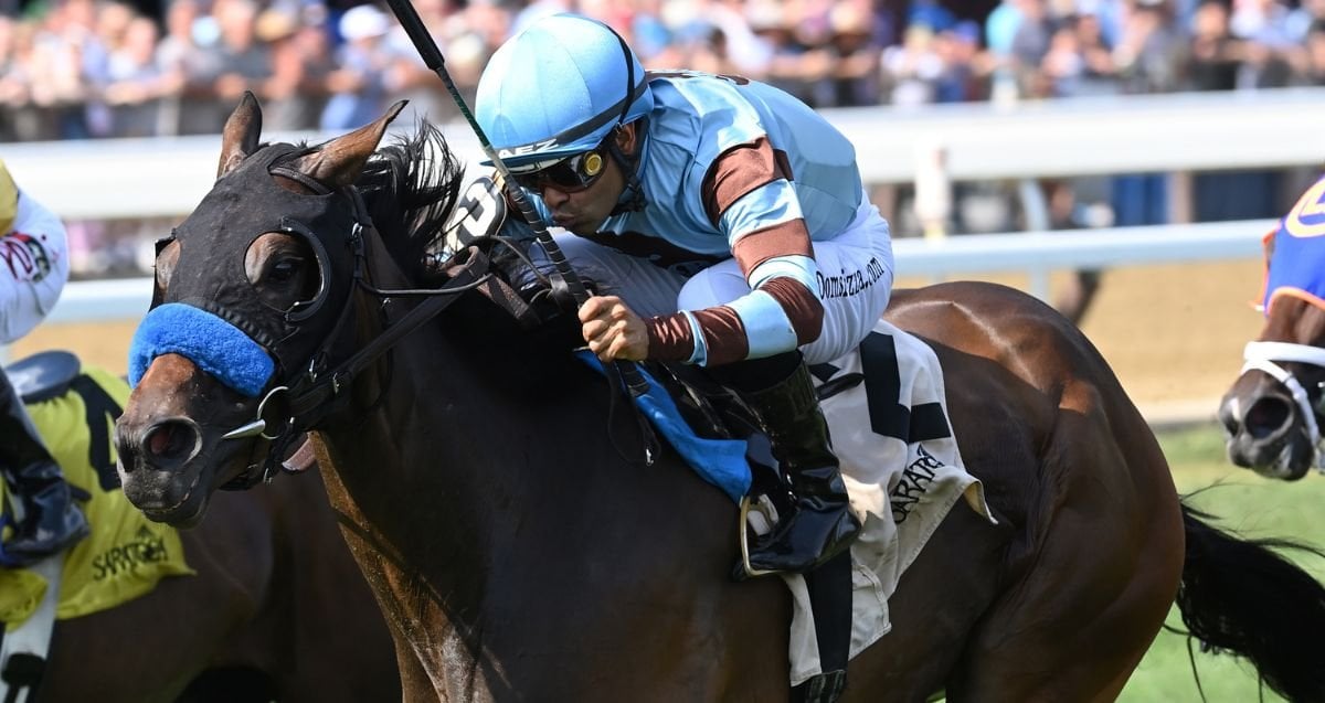 Thoroughbreds sprinting on Saratoga’s inner turf with grandstand crowds during the 2025 Summer Meet.