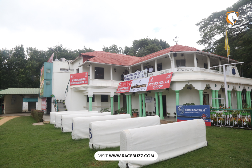 Promotional hoarding at the Bangalore Turf Club featuring the Zavaray S. Poonawalla Bangalore Summer Derby 2025, with bold graphics of galloping racehorses, event details, sponsor logos, and a countdown to the big race on Sunday, July 13.
