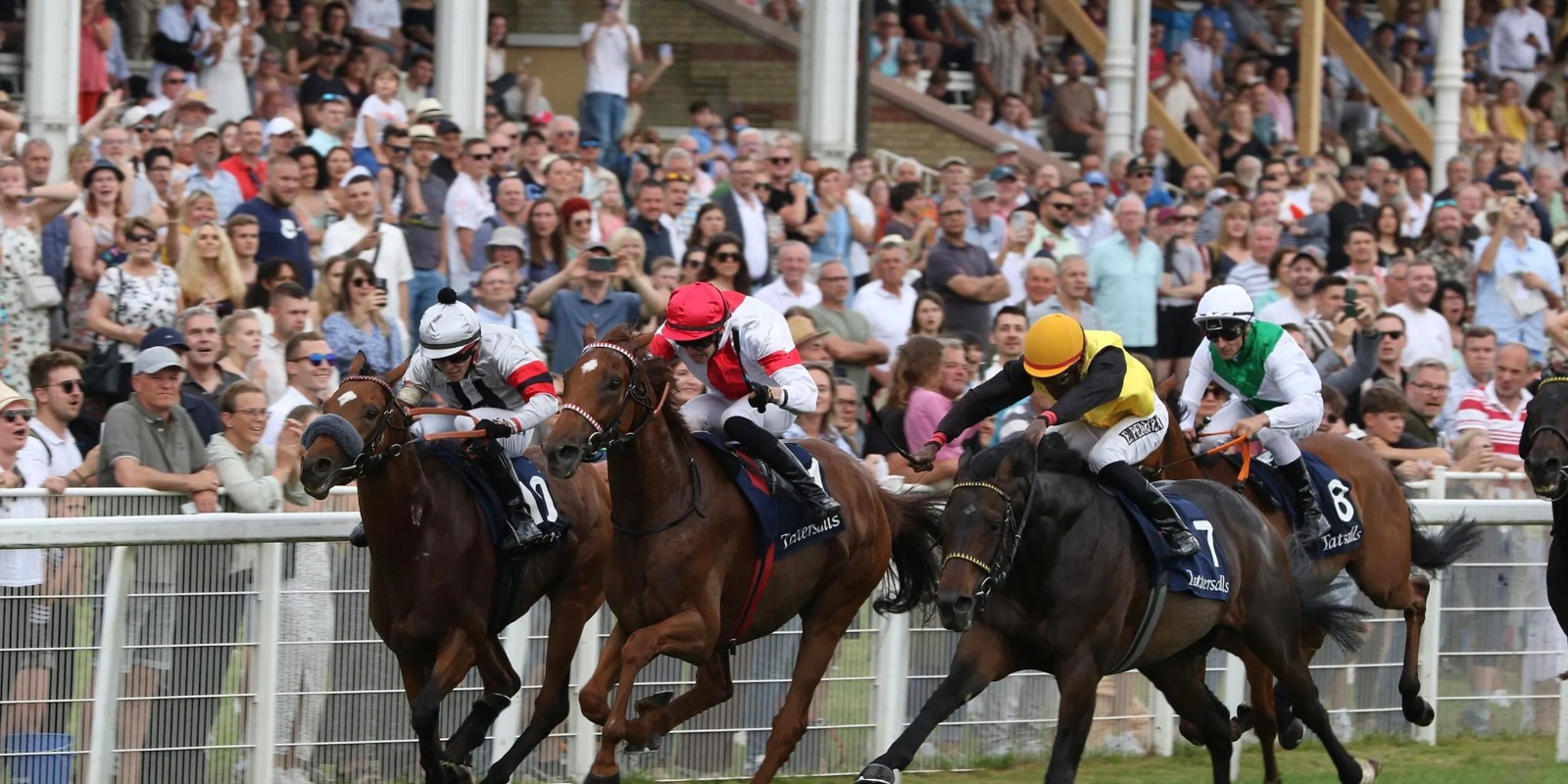 Crowds enjoying Baden-Baden Big Week 2025 races with horses and jockeys on the track