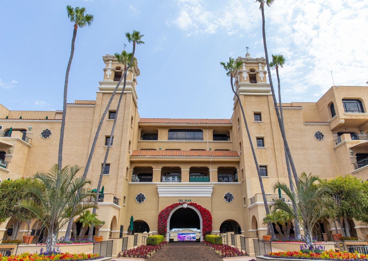 Horses jogging on the Del Mar dirt track after rain, preparing for the Native Diver Stakes